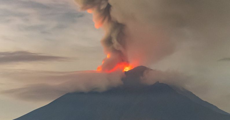 Jeju Lava - A large plume of smoke rises from the top of a mountain